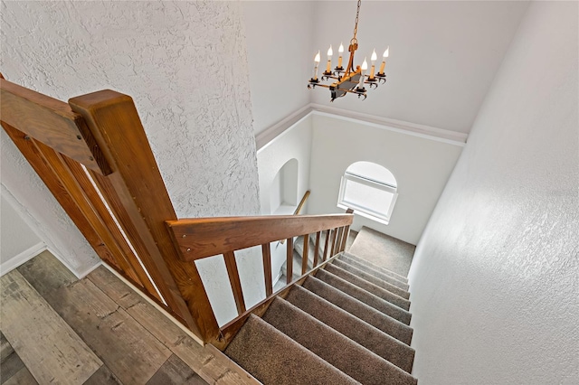 stairway featuring a notable chandelier and hardwood / wood-style flooring