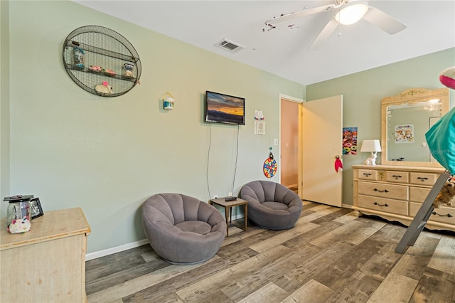 living area with hardwood / wood-style floors and ceiling fan