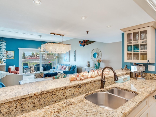 kitchen with light stone countertops, sink, and pendant lighting