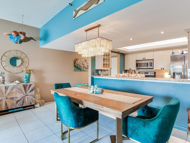 tiled dining space with an inviting chandelier