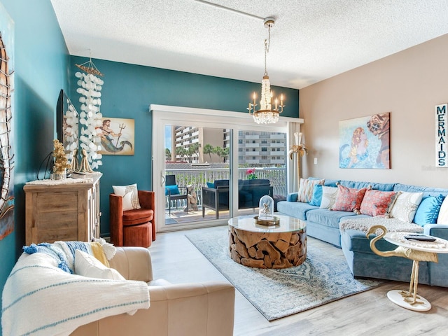 living room with a textured ceiling, an inviting chandelier, and hardwood / wood-style floors