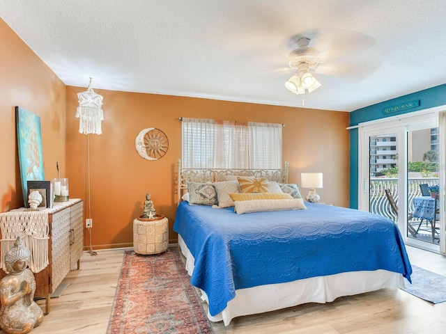 bedroom featuring ceiling fan, a textured ceiling, hardwood / wood-style flooring, and access to outside