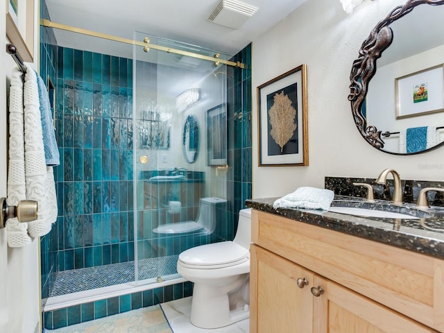 bathroom with a shower with shower door, vanity with extensive cabinet space, toilet, and tile floors