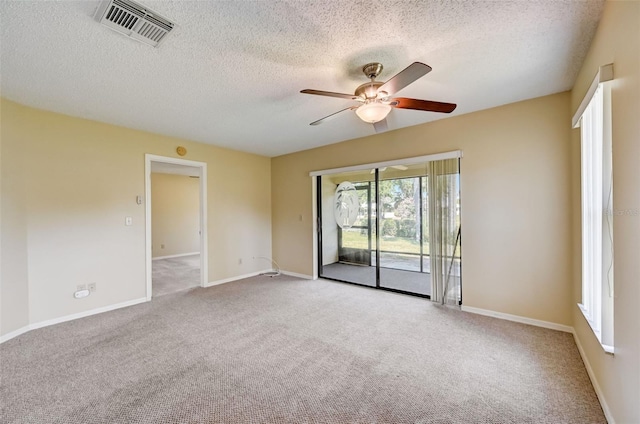 carpeted spare room featuring ceiling fan and a textured ceiling