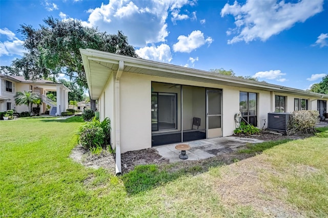 back of property featuring a yard and central AC unit