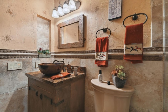 half bath featuring toilet, wainscoting, and vanity