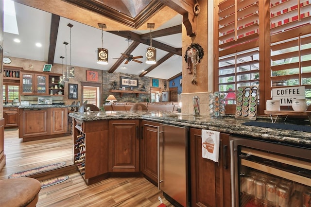 kitchen featuring beverage cooler, lofted ceiling with beams, dark stone countertops, and decorative light fixtures