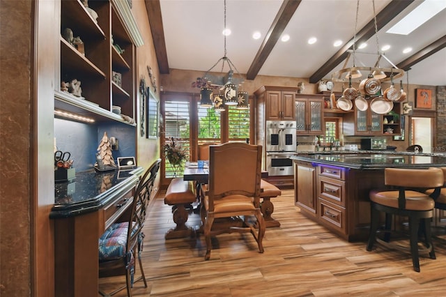 kitchen featuring glass insert cabinets, beamed ceiling, decorative light fixtures, a chandelier, and open shelves