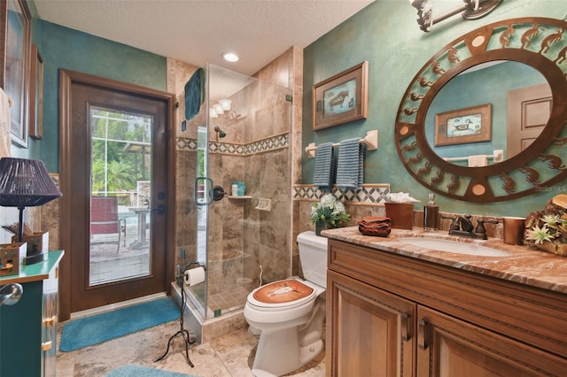 full bath featuring toilet, a stall shower, a textured ceiling, and vanity