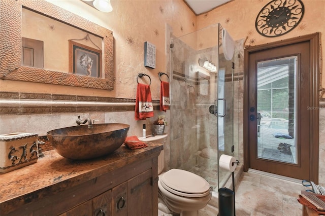 full bathroom with tile walls, a shower stall, toilet, and vanity