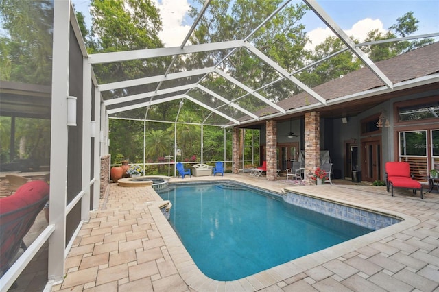 view of pool featuring ceiling fan, a patio, a lanai, and a pool with connected hot tub