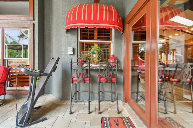 interior space with a textured wall and stone tile floors