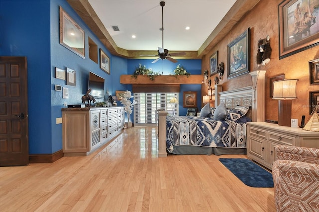 bedroom with baseboards, visible vents, a high ceiling, light wood-style floors, and recessed lighting