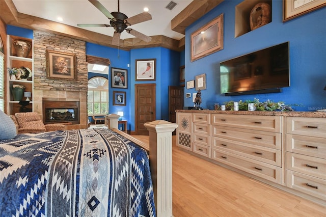 bedroom featuring light wood-type flooring, visible vents, and a fireplace