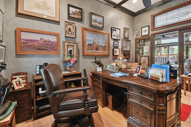 office featuring a textured wall, ornamental molding, light wood-type flooring, and a ceiling fan