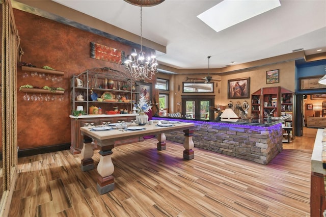 playroom featuring a skylight, french doors, baseboards, and wood finished floors