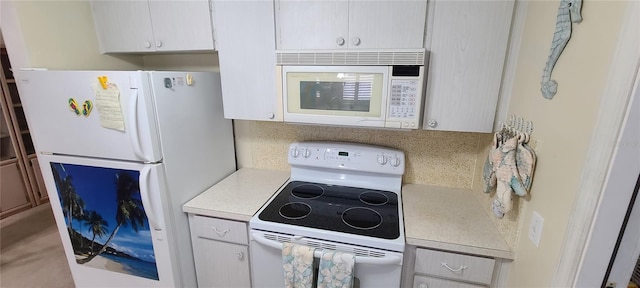 kitchen featuring backsplash, white appliances, and white cabinetry