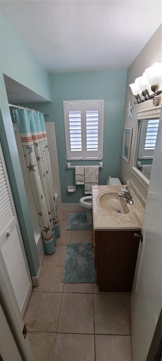 bathroom with tile floors, toilet, and oversized vanity