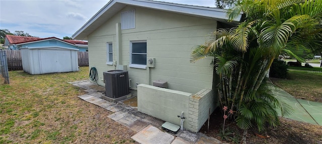 exterior space featuring a yard, central air condition unit, and a shed