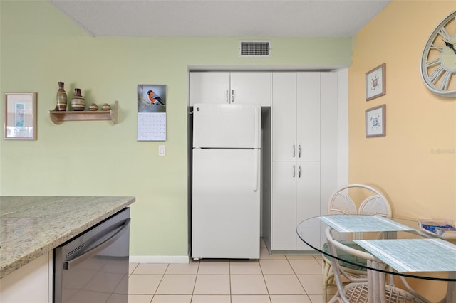 kitchen featuring white cabinetry, light stone counters, white refrigerator, light tile floors, and stainless steel dishwasher