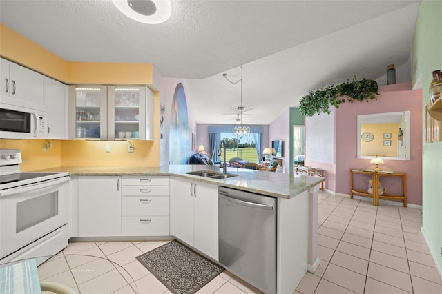 kitchen with white appliances, sink, light tile floors, and white cabinetry