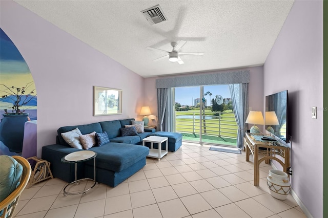 tiled living room with vaulted ceiling, ceiling fan, and a textured ceiling