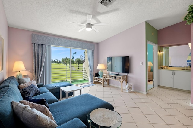 living room with vaulted ceiling, a textured ceiling, ceiling fan, and light tile floors