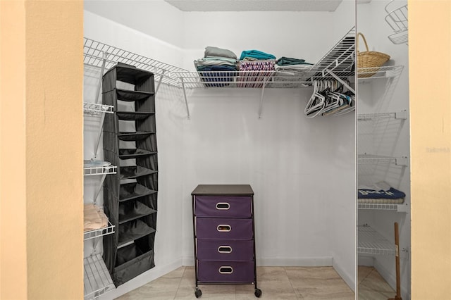 spacious closet with light tile flooring