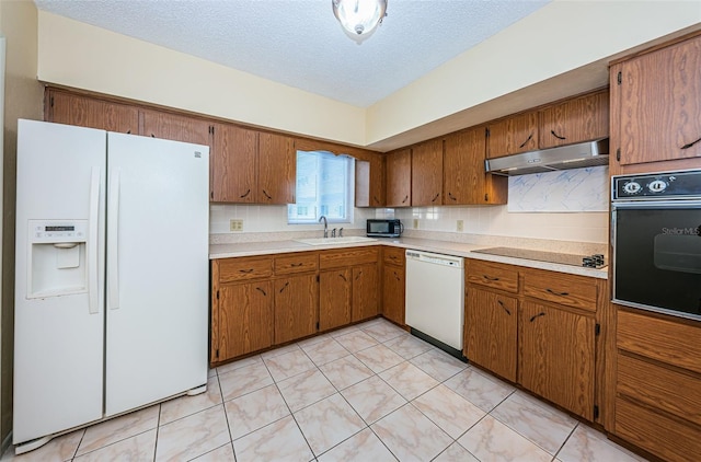 kitchen with light tile floors, black appliances, and a textured ceiling