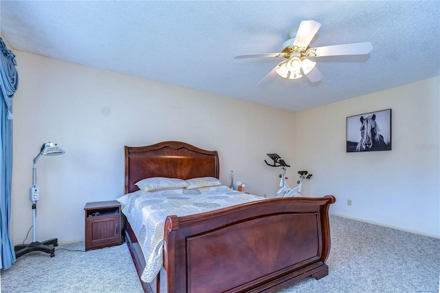 bedroom featuring light colored carpet, ceiling fan, and a textured ceiling