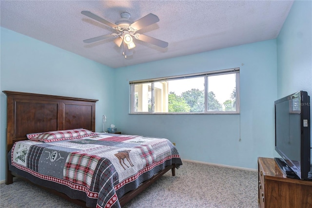 carpeted bedroom featuring ceiling fan and a textured ceiling