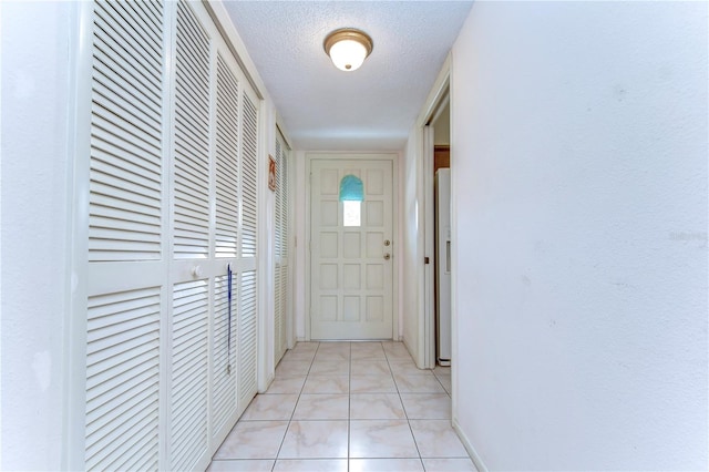 entryway featuring light tile floors and a textured ceiling