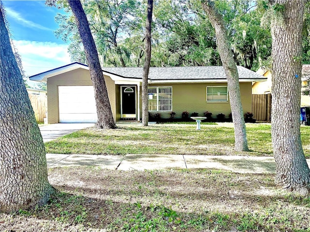 single story home featuring a garage and a front lawn