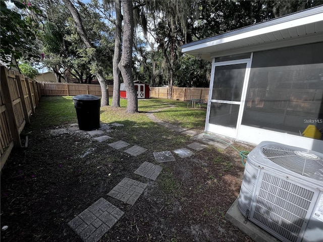 view of yard featuring a storage unit and central AC unit