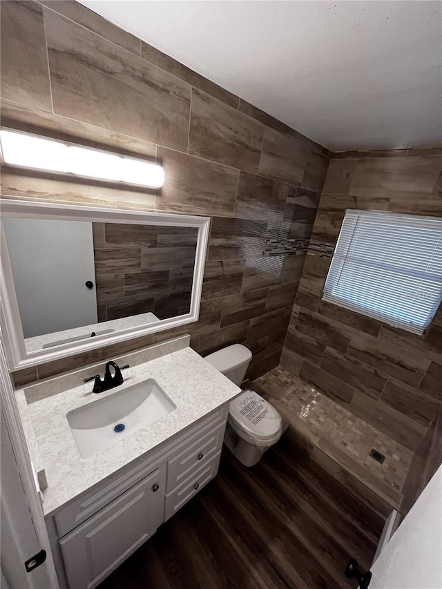 bathroom featuring tile walls, backsplash, large vanity, toilet, and hardwood / wood-style floors