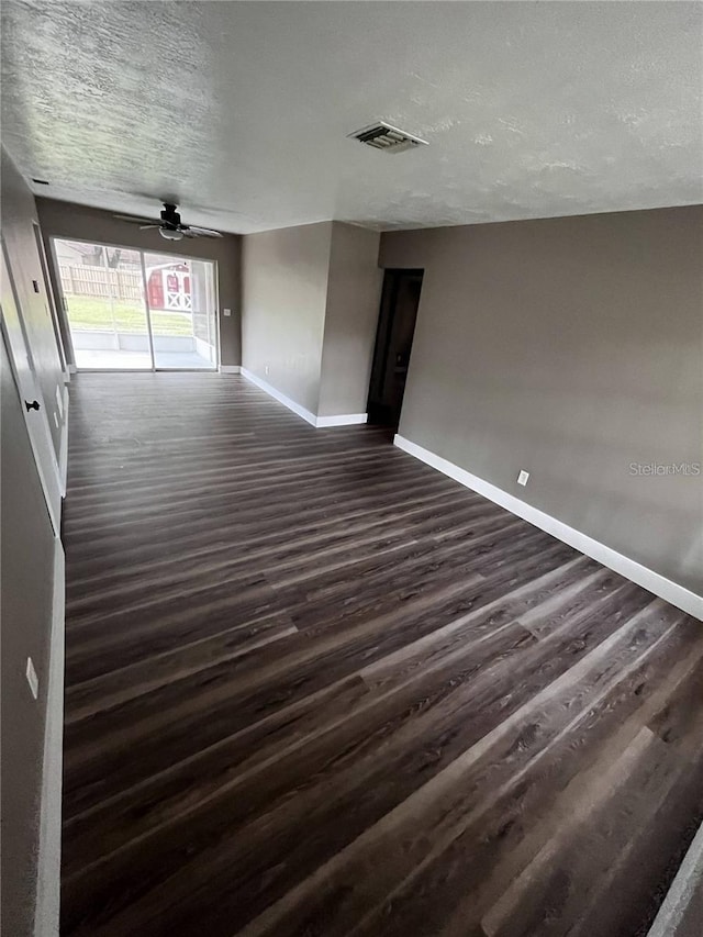 spare room with ceiling fan, dark wood-type flooring, and a textured ceiling