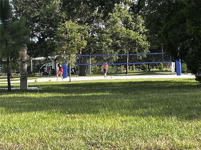 view of home's community featuring volleyball court and a lawn