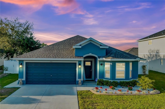 view of front of home featuring a lawn and a garage