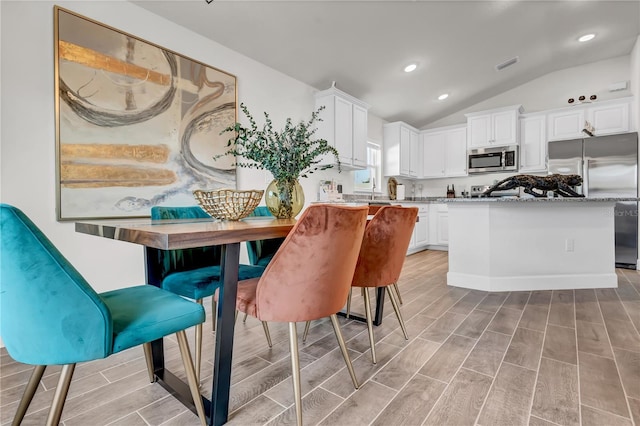 interior space with lofted ceiling and light hardwood / wood-style flooring