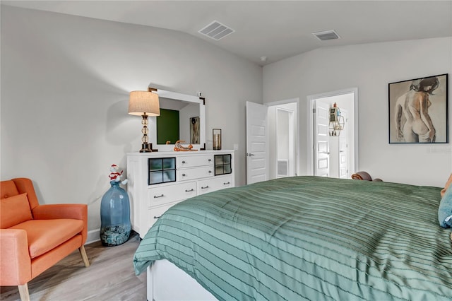 bedroom with vaulted ceiling and light hardwood / wood-style floors