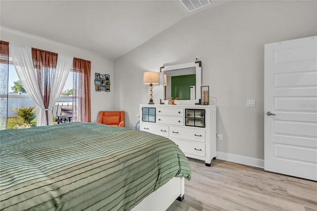 bedroom with lofted ceiling and light wood-type flooring