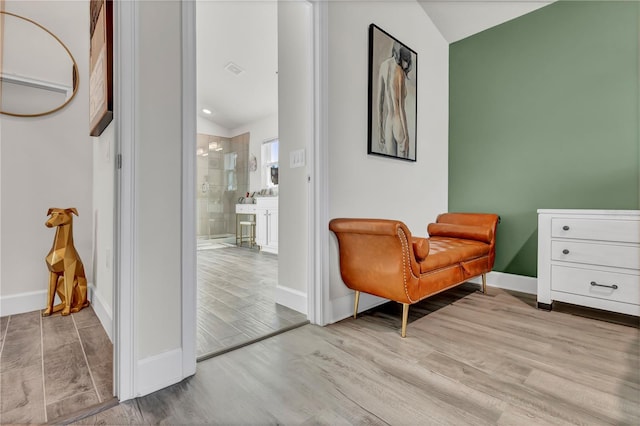 sitting room with wood-type flooring and lofted ceiling