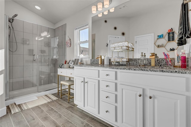 bathroom featuring lofted ceiling, an enclosed shower, and double sink vanity