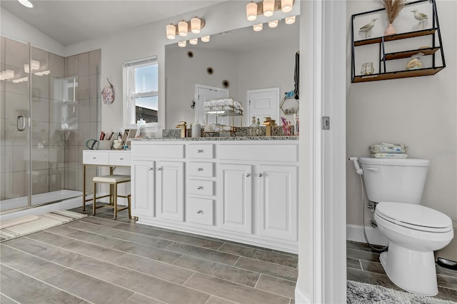 bathroom featuring a shower with shower door, toilet, oversized vanity, and tile floors