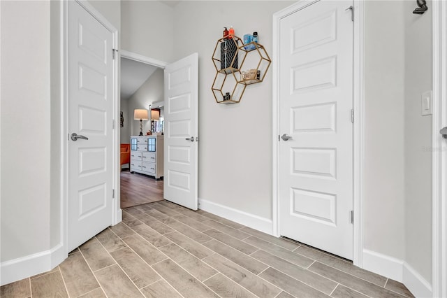 foyer entrance with light hardwood / wood-style flooring and lofted ceiling