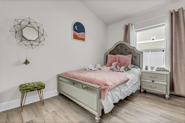 bedroom with hardwood / wood-style flooring and vaulted ceiling