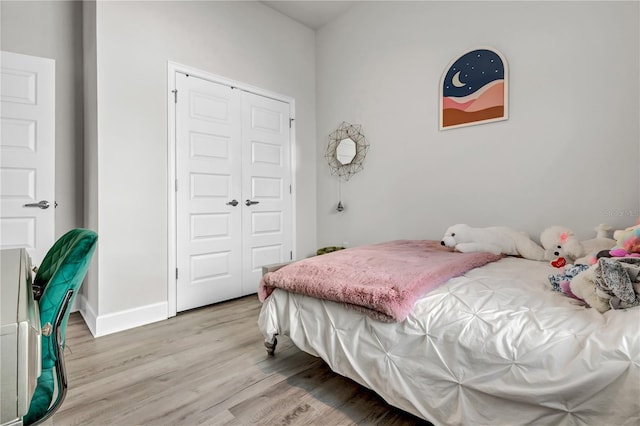 bedroom with light hardwood / wood-style floors and a closet