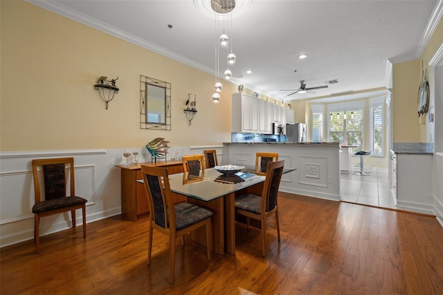 dining room featuring crown molding, ceiling fan, and light wood-type flooring