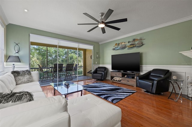 living room with a textured ceiling, ceiling fan, hardwood / wood-style flooring, and ornamental molding