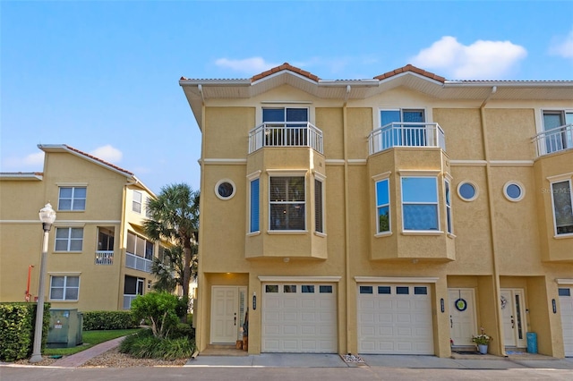 view of property with a balcony and a garage